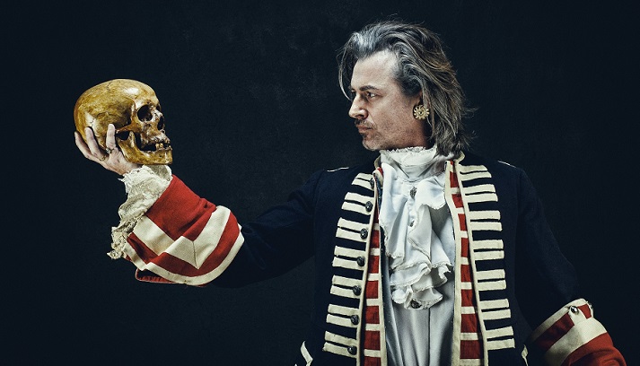 actor holding a skull prop