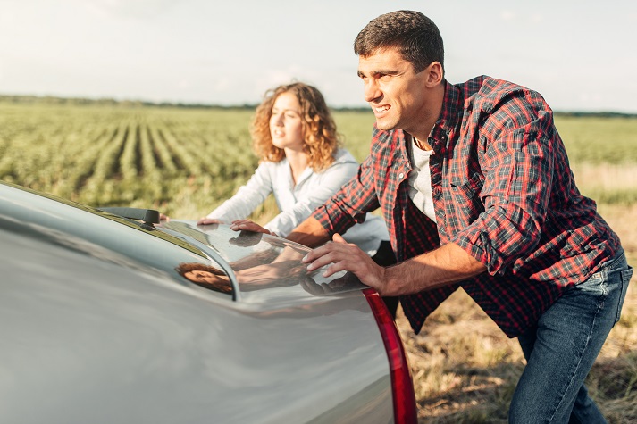 man and woman pushing a car