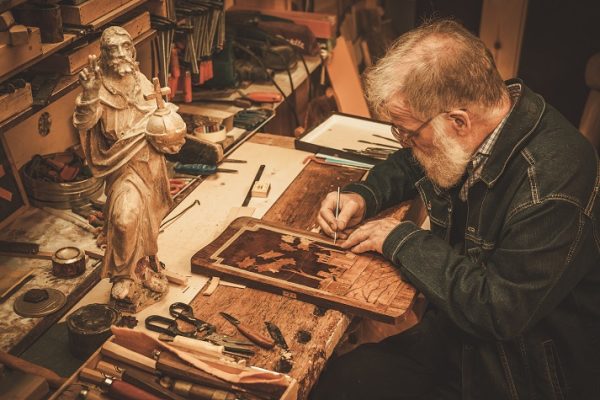 Senior restorer working with antique decor element in his workshop Online School